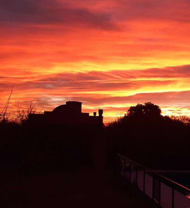 Cielo en tonos naranja y rosa sobre las sierras desde Punto Serrano, Carpintería
